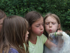 Kinder pusten in die Glut